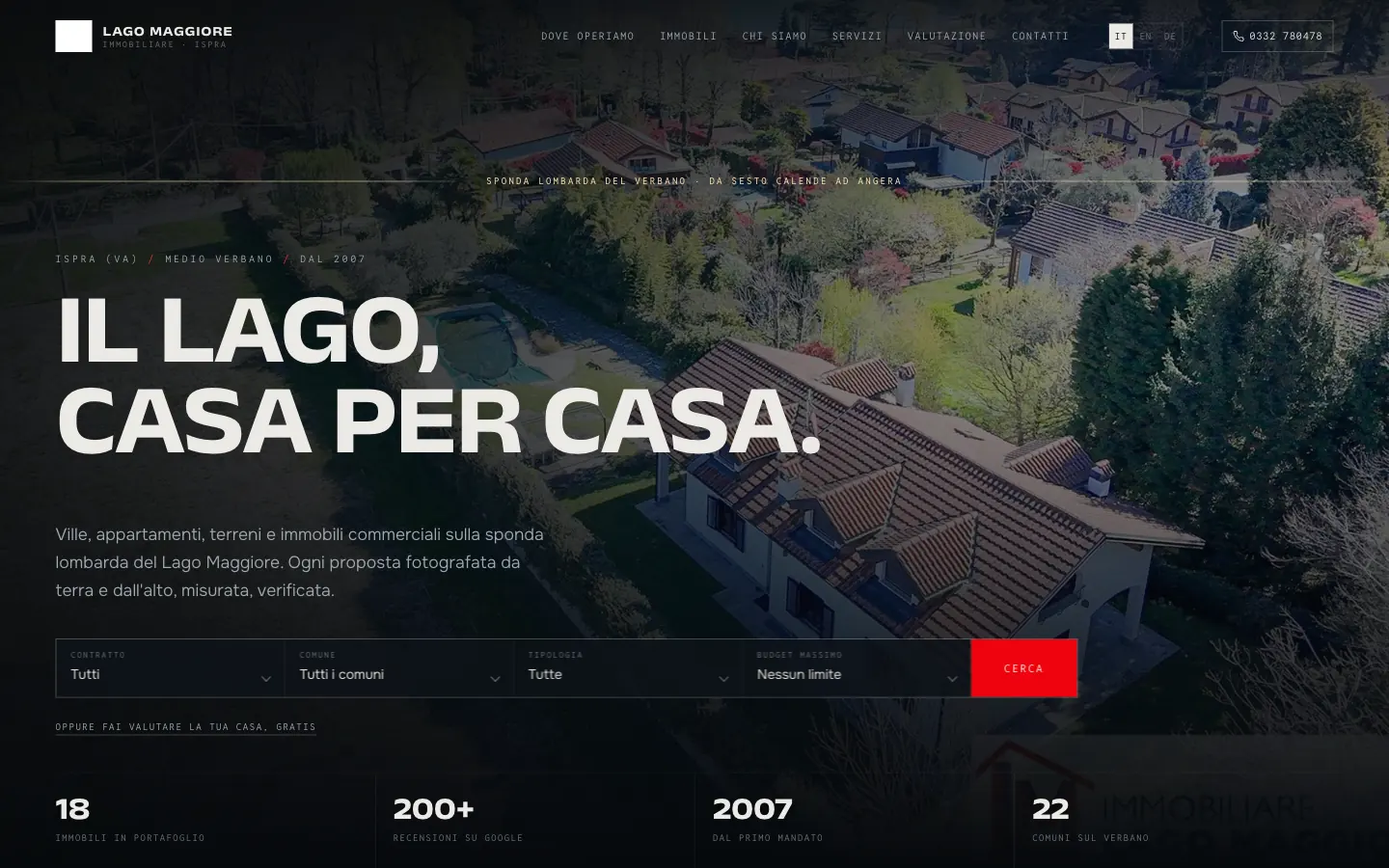 La home di un sito di agenzia immobiliare: titolo a piena pagina sopra una veduta aerea, ricerca a filtri per contratto, comune, tipologia e budget, selettore di lingua e i numeri dell’agenzia in fondo.